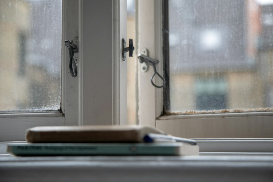 author writing notes by window